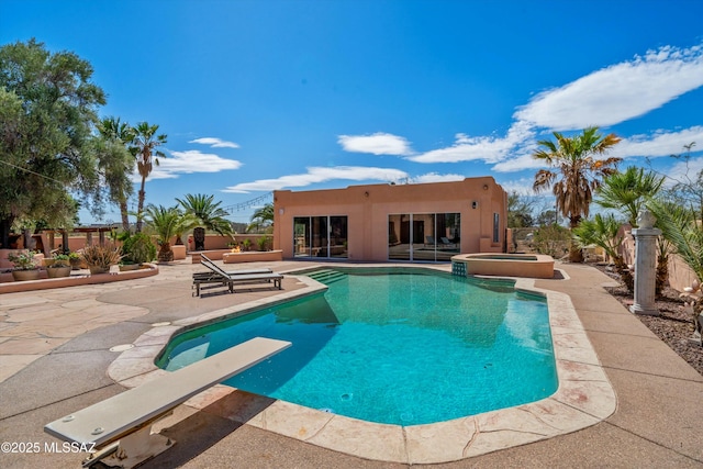 view of pool featuring a diving board, a pool with connected hot tub, and a patio