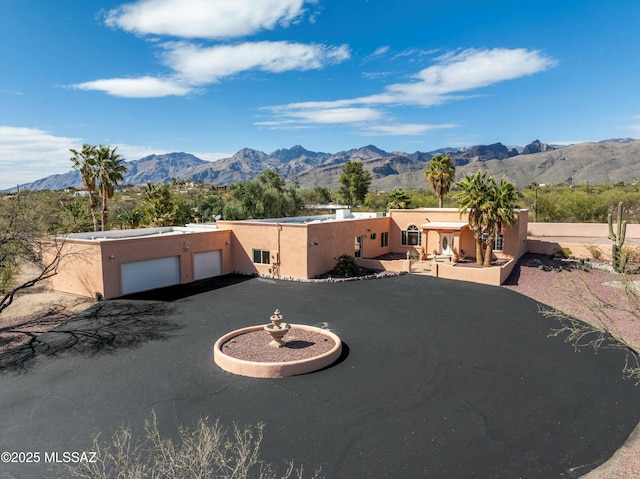 view of front of property featuring stucco siding, a garage, and a mountain view