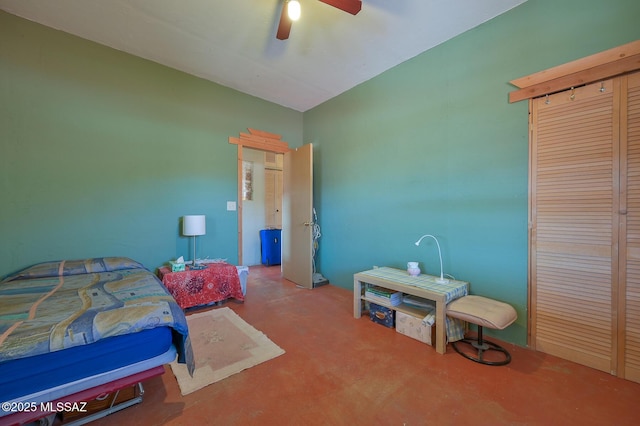 bedroom featuring a ceiling fan, finished concrete floors, and a closet