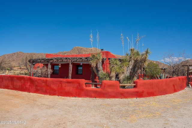 view of property exterior with fence and a mountain view
