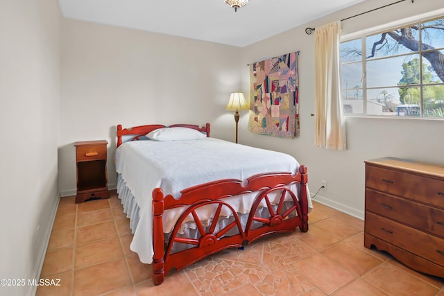 bedroom featuring light tile patterned floors and baseboards