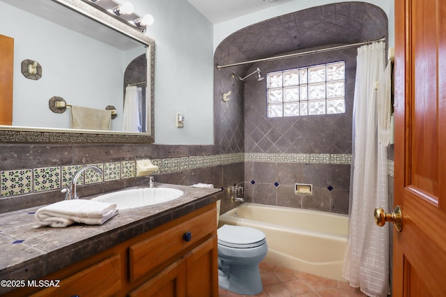 full bath featuring vanity, shower / tub combo, tile walls, toilet, and tile patterned floors