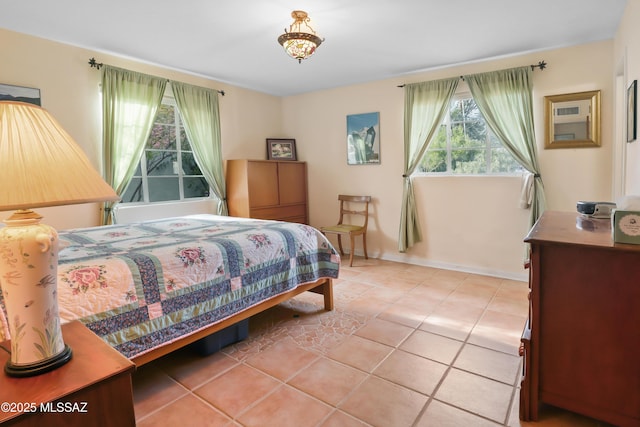 bedroom featuring baseboards and light tile patterned floors