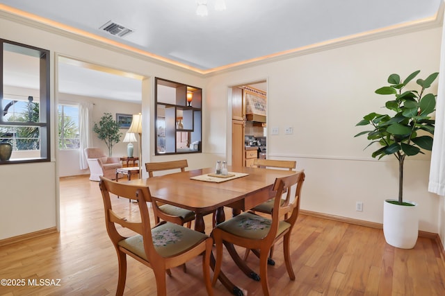 dining space featuring ornamental molding, baseboards, light wood finished floors, and visible vents