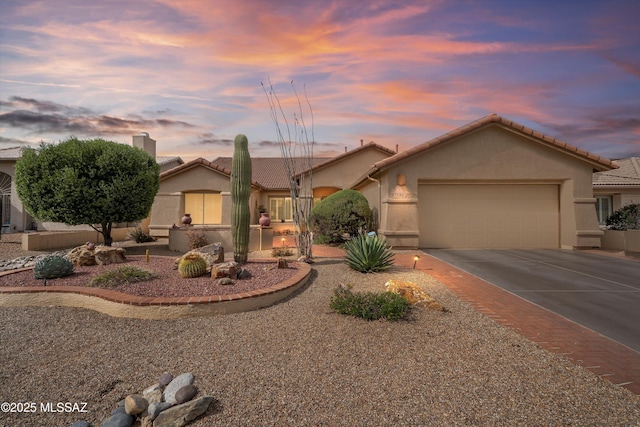 view of front of house featuring concrete driveway, stucco siding, a chimney, a garage, and a tiled roof