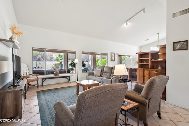 living area with track lighting, high vaulted ceiling, light tile patterned flooring, and visible vents