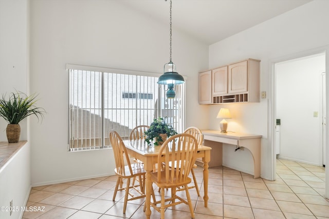 dining area featuring high vaulted ceiling, baseboards, and light tile patterned flooring