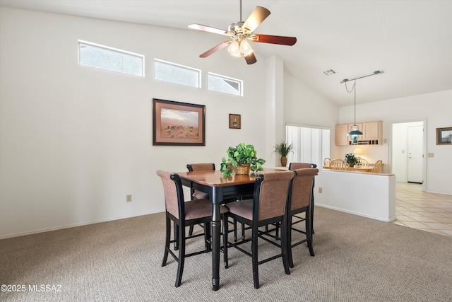 dining space with high vaulted ceiling, light tile patterned floors, light colored carpet, a ceiling fan, and visible vents