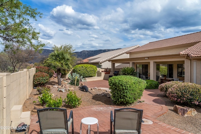view of patio featuring a mountain view and fence