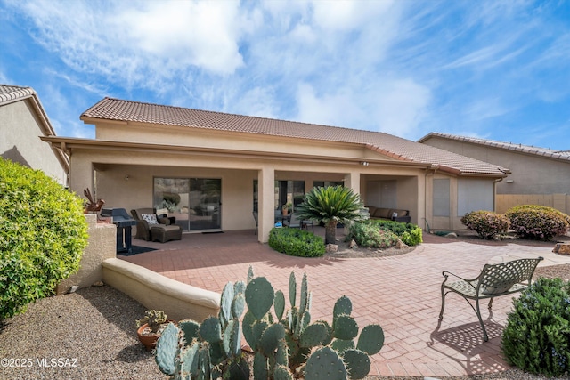 back of house featuring a patio, stucco siding, fence, and a tile roof