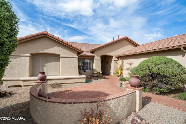 exterior space with a patio area, stucco siding, and a tile roof