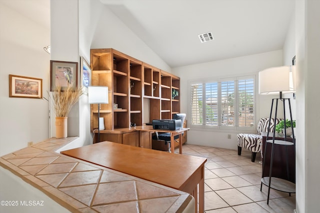 home office with visible vents, light tile patterned floors, and lofted ceiling