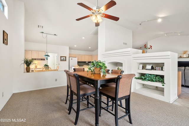 dining space featuring high vaulted ceiling, ceiling fan, rail lighting, light colored carpet, and recessed lighting