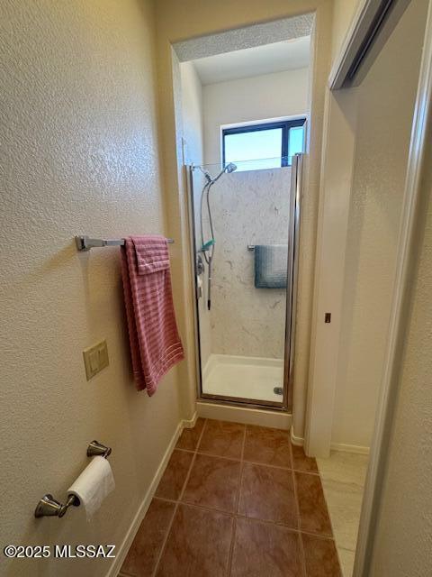 4769 S Meadow Ridge Dr, Green Valley, AZ 85622 - bathroom featuring a stall shower, tile patterned flooring, baseboards, and a textured wall