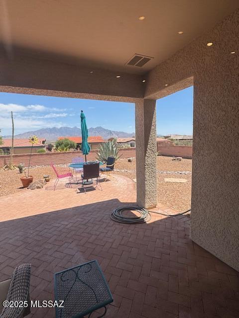 4769 S Meadow Ridge Dr, Green Valley, AZ 85622 - fenced backyard with a mountain view, outdoor dining space, and a patio
