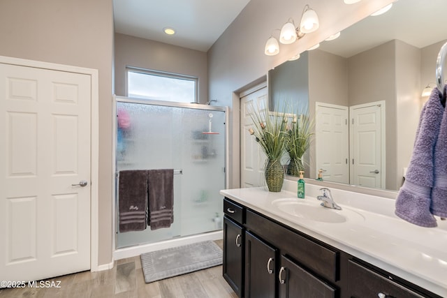 full bathroom featuring baseboards, a shower stall, vanity, and wood finished floors