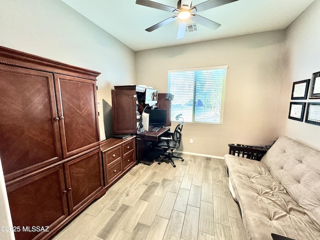 office with baseboards, visible vents, light wood-type flooring, and a ceiling fan