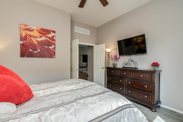 bedroom featuring visible vents, baseboards, ceiling fan, and wood finished floors