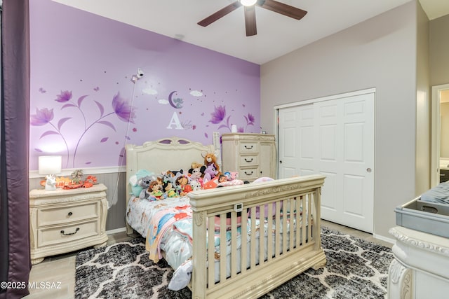 bedroom featuring a wainscoted wall and ceiling fan