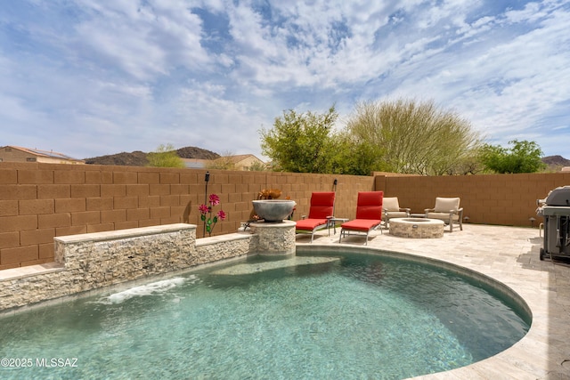 view of pool featuring an outdoor fire pit, a patio, grilling area, fence, and a fenced in pool