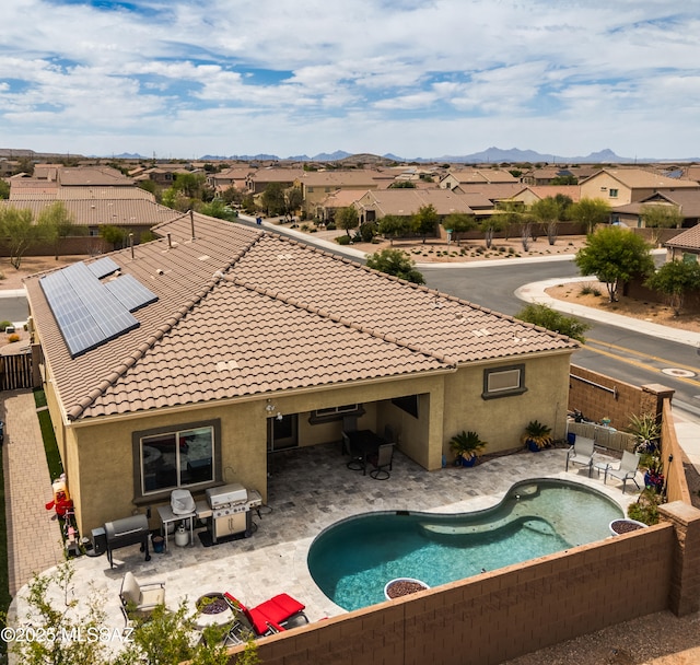 pool featuring a mountain view, a patio area, a fenced backyard, and a residential view