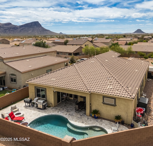 view of pool with a mountain view, a patio area, a fenced backyard, and a residential view