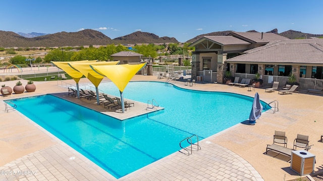 pool featuring a mountain view, a patio, and fence