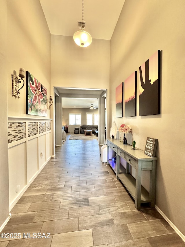hall with visible vents and wood finish floors