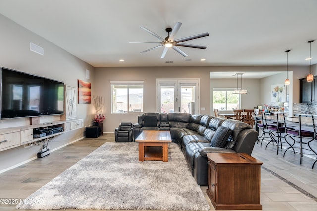 living room featuring light wood-style floors, a ceiling fan, visible vents, recessed lighting, and baseboards