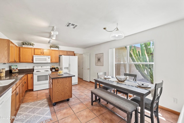 3398 W Sagebrush Hills Ct, Tucson, AZ 85741 - kitchen with dark countertops, white appliances, light tile patterned floors, a kitchen island, and visible vents
