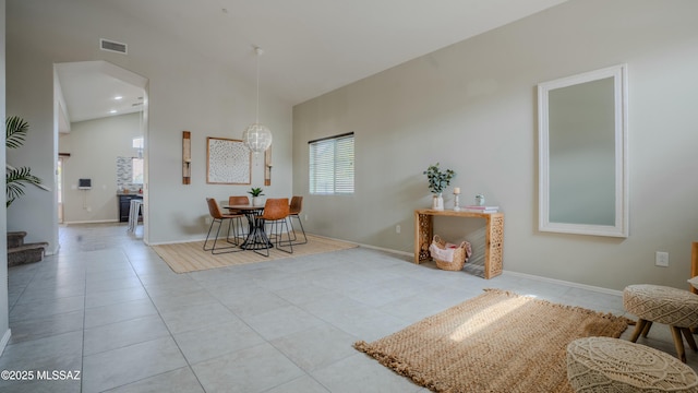 8754 W Denstone Rd, Marana, AZ 85653 - tiled dining room featuring arched walkways, a towering ceiling, baseboards, and stairs