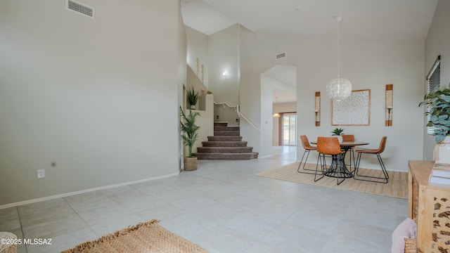 8754 W Denstone Rd, Marana, AZ 85653 - dining space featuring high vaulted ceiling, stairway, and baseboards