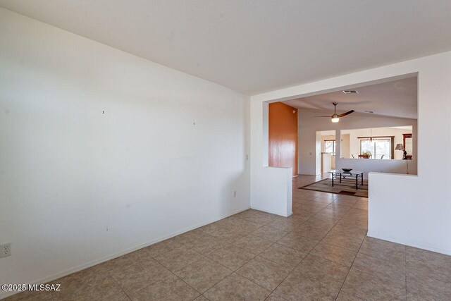 spare room featuring baseboards, lofted ceiling, ceiling fan, and visible vents