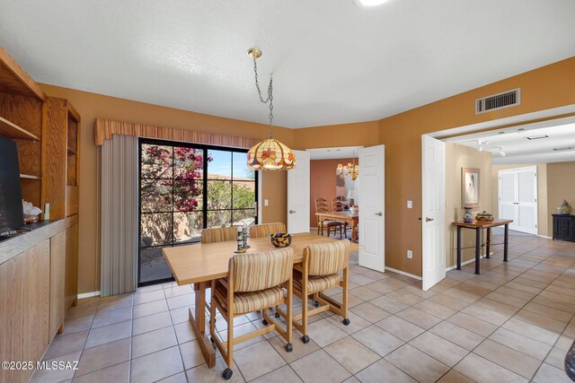 dining room featuring light tile patterned floors, visible vents, and baseboards