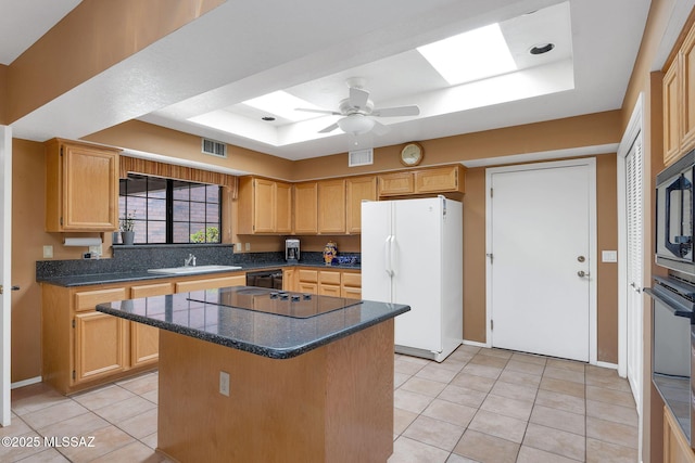 kitchen with light tile patterned floors, a sink, a raised ceiling, visible vents, and black appliances