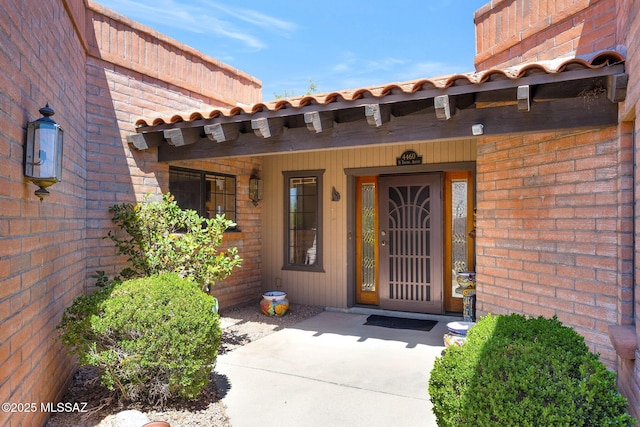 entrance to property featuring brick siding