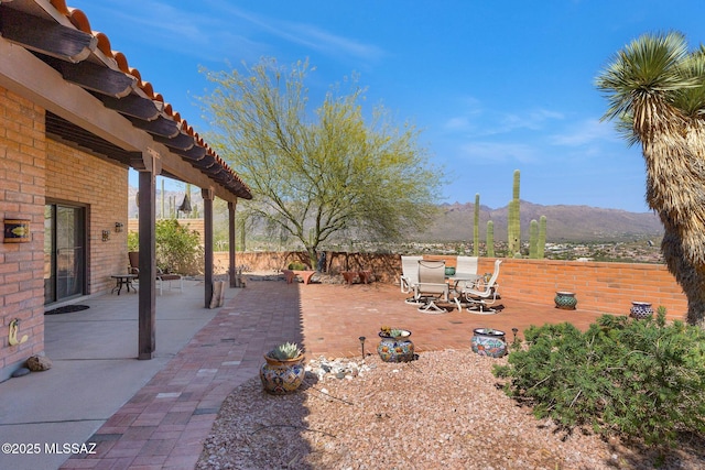 view of yard featuring a mountain view, outdoor dining area, a patio, and fence