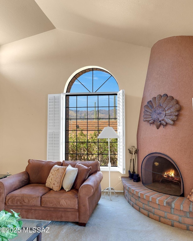 living room with a large fireplace, carpet floors, and lofted ceiling