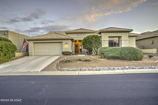 62583 E Amberwood Dr, Saddlebrooke, AZ 85739 - mediterranean / spanish-style home featuring stucco siding, an attached garage, a tile roof, and concrete driveway