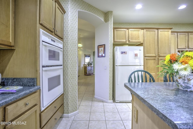 62583 E Amberwood Dr, Saddlebrooke, AZ 85739 - kitchen featuring white appliances, baseboards, wallpapered walls, dark countertops, and light tile patterned floors