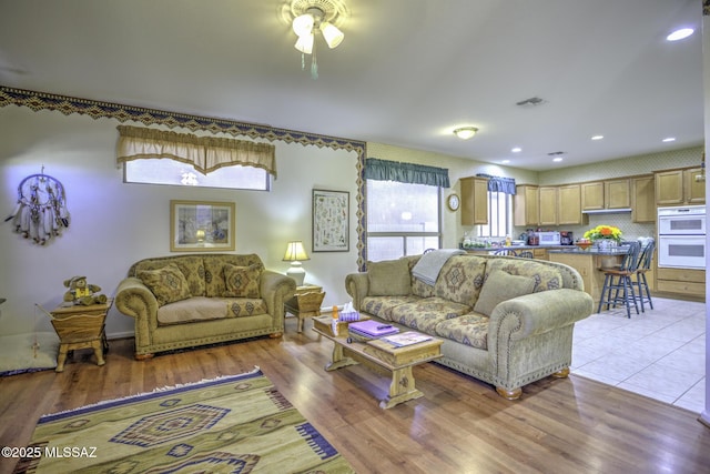 62583 E Amberwood Dr, Saddlebrooke, AZ 85739 - living area featuring visible vents, light wood-style floors, and a ceiling fan