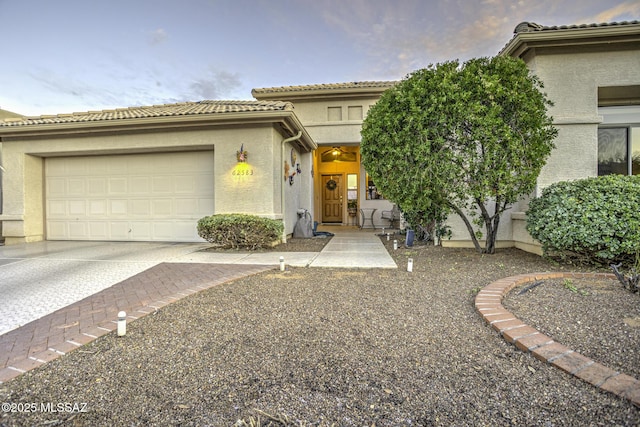 62583 E Amberwood Dr, Saddlebrooke, AZ 85739 - view of front of house with stucco siding, an attached garage, a tile roof, and concrete driveway