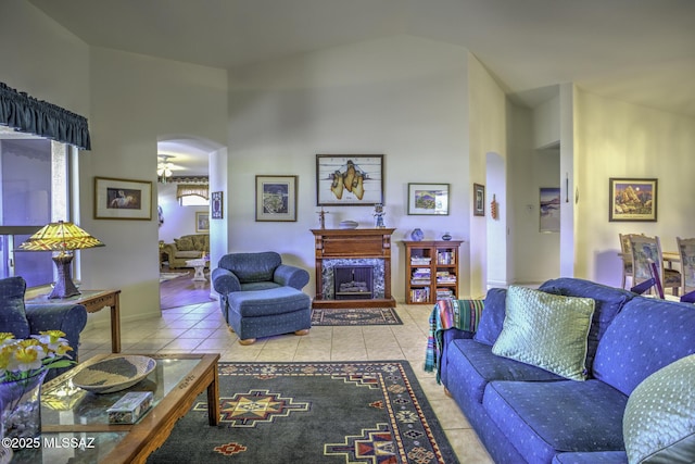 62583 E Amberwood Dr, Saddlebrooke, AZ 85739 - tiled living room featuring arched walkways, high vaulted ceiling, a premium fireplace, and ceiling fan