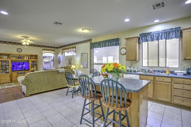62583 E Amberwood Dr, Saddlebrooke, AZ 85739 - kitchen featuring a kitchen breakfast bar, open floor plan, dark countertops, light tile patterned floors, and visible vents
