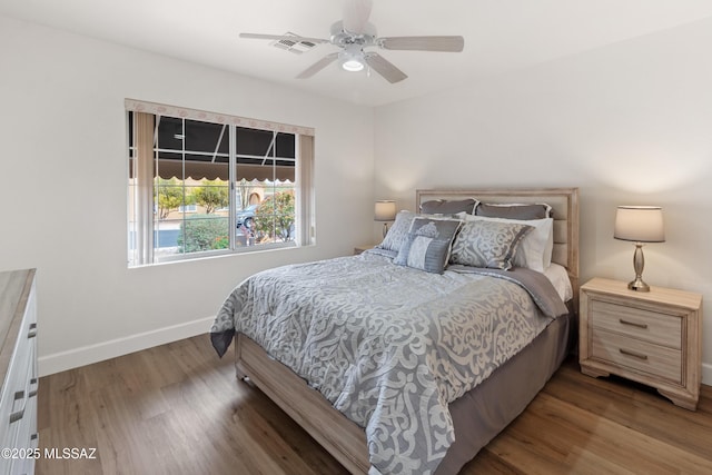 bedroom with baseboards, visible vents, wood finished floors, and a ceiling fan