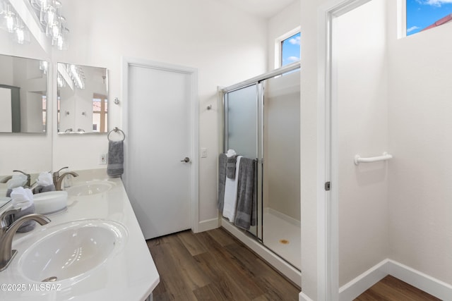 full bathroom featuring a stall shower, wood finished floors, and a sink