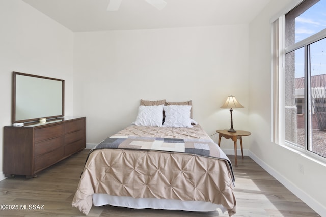 bedroom with baseboards, wood finished floors, and a ceiling fan