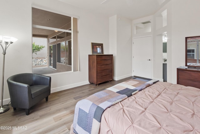 bedroom featuring baseboards and wood finished floors