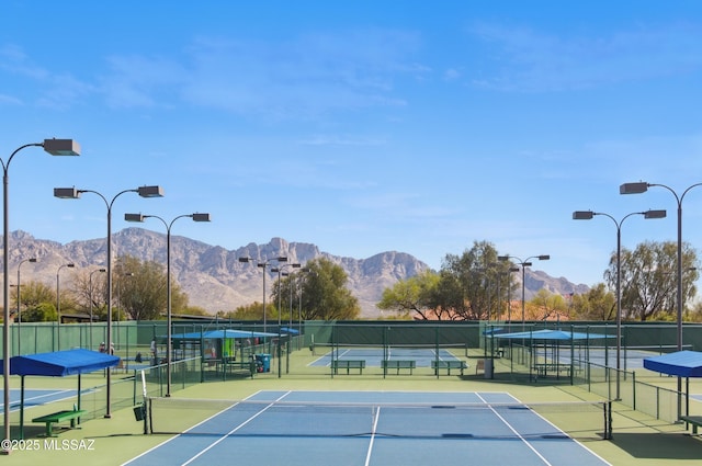 view of sport court featuring community basketball court, fence, and a mountain view