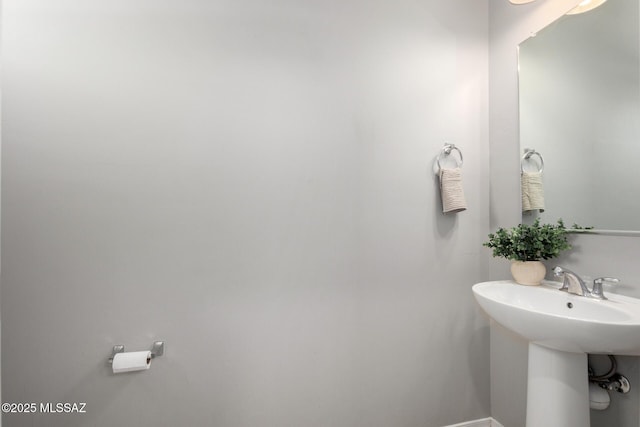 bathroom featuring a sink and baseboards